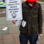 I.W.W. member holding a placard.